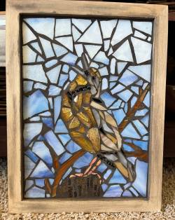 Stained glass artwork showing a bird on a stump by Robin Bosch