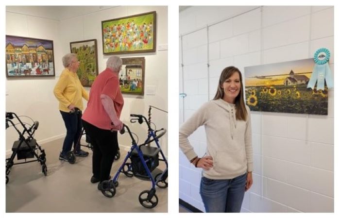 Visitors look at paintings on the wall; a woman stands next to a photograph of a church and sunflowers.